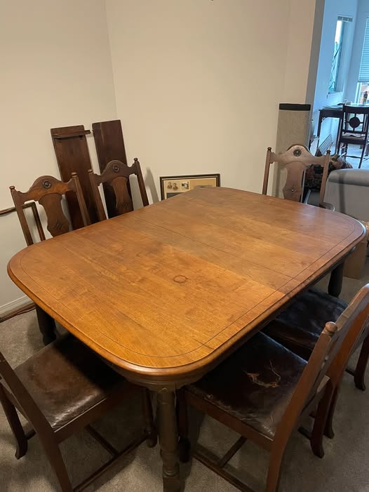 A large wooden dining table and matching chairs offered by Deb Anderson in the Oak Bay Local Facebook group.