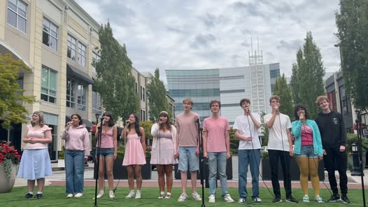 The cast of RENT performing Seasons of Love together outdoors at Uptown.